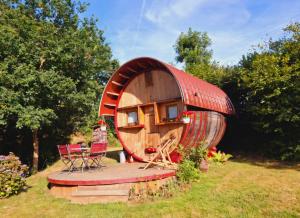 a small tree house with a deck and chairs in the yard at L'authentique Tonneau à Cidre d'Emma in Litteau +37 photos