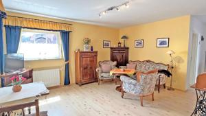 a living room with a table and chairs at Villa Vivien, Ostsee Findling App 4 - Bade- & Saunawelt täglich inklusive in Göhren