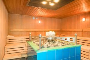 a sauna with a tub in a room with wooden walls at Villa Vivien, Ostsee Findling App 4 - Bade- & Saunawelt täglich inklusive in Göhren