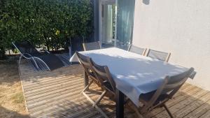 a white table and chairs on a deck at Maison le palmier in Troarn +6 photos