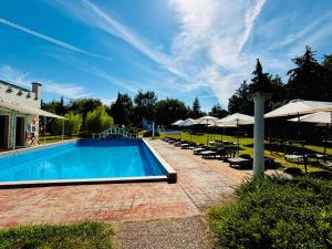 a swimming pool with chairs and umbrellas at Bungalow Park Balatonboglár in Balatonboglár
