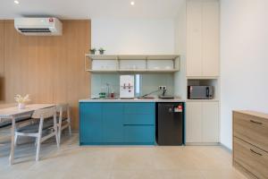 a kitchen with blue cabinets and a sink and a table at 22 Macalisterz by YourSuperhost in George Town