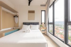 a bedroom with a large bed and large windows at 22 Macalisterz by YourSuperhost in George Town