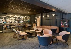 a restaurant with chairs and tables and a bar at B&B HOTEL Cergy Port 4 étoiles in Cergy
