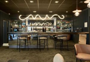 a bar in a restaurant with bar stools at B&B HOTEL Cergy Port 4 étoiles in Cergy