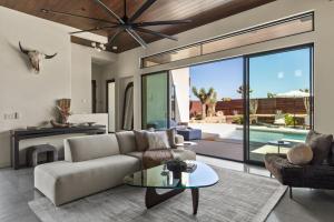 a living room with a couch and a table at Windsong Modern compound w pool spa in Yucca Valley