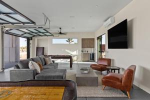 a living room with a couch and a piano at Windsong Modern compound w pool spa in Yucca Valley