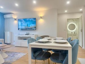a dining room with a white table and blue chairs at Angel MINT Apartment - FREE PARKING - Balcony in Krakow +112 photos