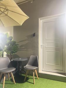 two chairs and a table in front of a door at LA COSTA DI SAN GIORGIO in Agios Georgios