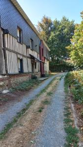 a dirt road in front of a building at La Bouee, entre Manche et Seine in Saint-Nicolas-de-la-Haie