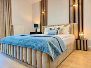 a bedroom with a large bed with a blue blanket at Angel MINT Apartment - FREE PARKING - Balcony in Krakow