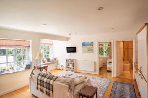 a living room with a couch and a tv at The Cottage Hankerton Priory in Hankerton