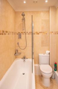 a bathroom with a white tub and a toilet at The Cottage Hankerton Priory in Hankerton +16 photos