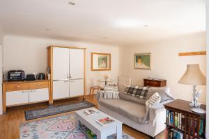 a living room with a couch and a table at The Cottage Hankerton Priory in Hankerton
