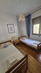 two beds in a room with a window at Sun Apartment in Petrovac na Moru