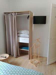 a small bedroom with a bed and a small closet at A la ferme chez Christian in Escaudoeuvres