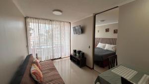 a hotel room with a bed and a mirror at Departamentos Alpro Cavancha Vista a la Playa in Iquique