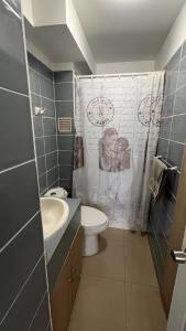 a bathroom with a sink and a toilet and a shower at Departamentos Alpro Cavancha Vista a la Playa in Iquique +36 photos