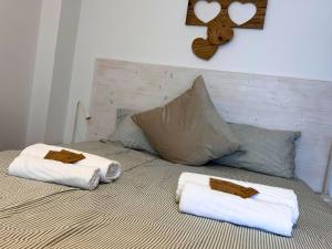 a bed with two towels on top of it at Reunia apartments in Ragogna
