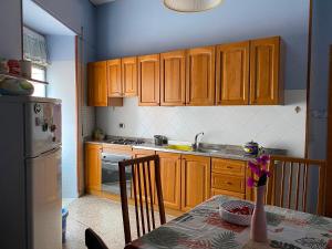 a kitchen with wooden cabinets and a table with a vase at Appartamento Nonna Ida in Montesarchio