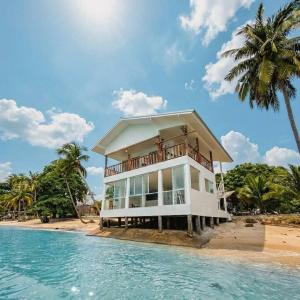 a house on the beach with a palm tree at Beach Terrace Studio - WaveSide Ocean Bliss in Thong Sala