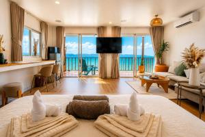 a bedroom with a bed and a living room at Beach Terrace Studio - WaveSide Ocean Bliss in Thong Sala