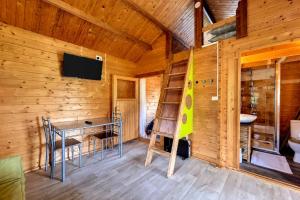 a room with a table and a tv in a cabin at Le Yucca - Terrasse et jardin - Wifi in Saint-Louis