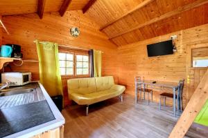 a living room with a couch and a television in a cabin at Le Yucca - Terrasse et jardin - Wifi in Saint-Louis