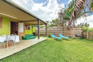 a patio with a table and chairs on the grass at Le Yucca - Terrasse et jardin - Wifi in Saint-Louis