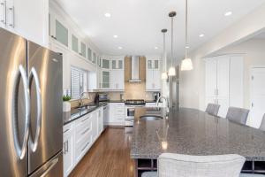 a kitchen with white cabinets and a stainless steel refrigerator at Family-Friendly 3BR Home in Vancouver
