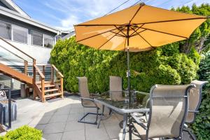 a patio with a table with an umbrella and chairs at Family-Friendly 3BR Home in Vancouver