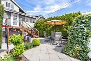 a patio with an umbrella and a table and chairs at Family-Friendly 3BR Home in Vancouver