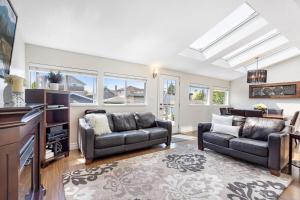 a living room with two couches and a tv at Family-Friendly 3BR Home in Vancouver +37 photos