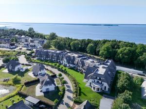 an aerial view of a residential neighborhood with houses and the water at Apartmenthaus Resort Kranichsruh in Fuhlendorf