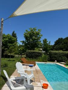 a swimming pool with two lawn chairs and an umbrella at Las Rosas in Mar Azul