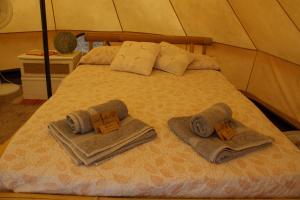 a bed in a tent with towels and pillows at Bellissima Bell Tent - Romantic Glamping Retreat in Nature in Tortosa +99 photos