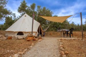 a tent with a table and chairs in a field at Bellissima Bell Tent - Romantic Glamping Retreat in Nature in Tortosa