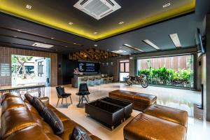 武里南Cresco Hotel Buriram的一间带皮革家具和酒吧的客厅