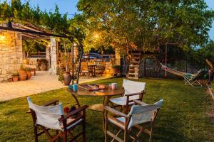 a patio with a table and chairs in a yard at Petalidi Olive Garden Stone House near the beach in Petalidi
