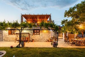 a patio with a table and chairs and a building at Petalidi Olive Garden Stone House near the beach in Petalidi