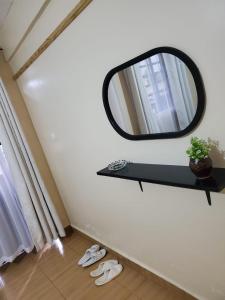 a mirror on a wall with a shelf and shoes at Star Villas Nyahururu in Nyahururu