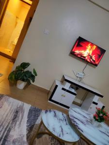 a living room with a tv and a table and chairs at Star Villas Nyahururu in Nyahururu