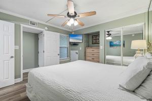 a bedroom with a bed and a ceiling fan at Seventh-floor oceanfront condo with pool access ocean view & central AC in Fort Walton Beach