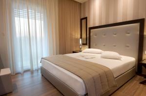 a bedroom with a large bed and a large window at Louloudis Fresh-Adults Only in Skala Rachoniou