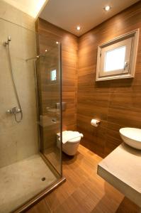 a bathroom with a shower and a toilet and a sink at Louloudis Fresh-Adults Only in Skala Rachoniou