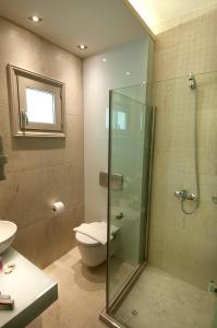 a bathroom with a toilet and a glass shower at Louloudis Fresh-Adults Only in Skala Rachoniou
