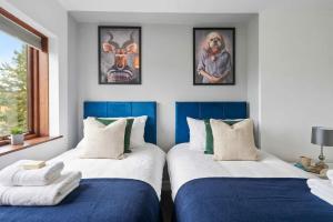 two beds in a room with paintings on the wall at Spacious 3BED Home in Rugby - Ideal for Groups in Clifton upon Dunsmore