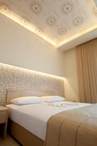 a bedroom with two beds and a ceiling at Louloudis Fresh-Adults Only in Skala Rachoniou