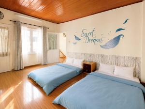 two beds in a room with a wall with words sweet dreams at Nhà Của Thỏ Vân Anh in Da Lat +14 photos