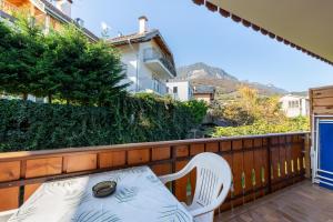 a balcony with a white chair and a table at Apartments Burgunderhof in Termeno